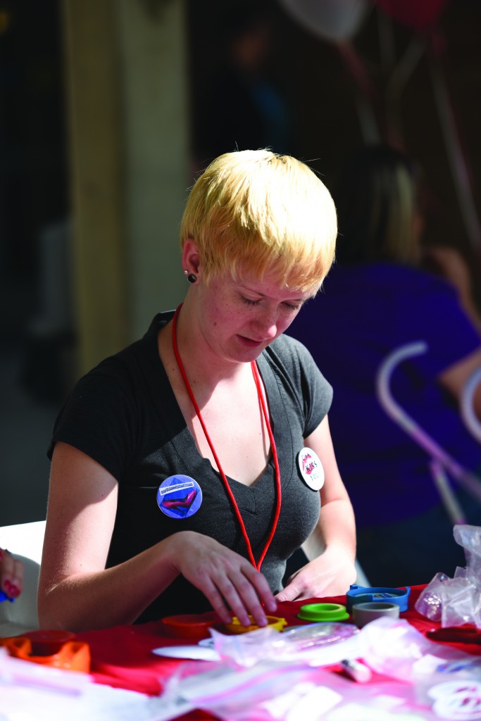 Senior Amanda Gibb, a SAAVI intern volunteers at the Red Zone booth during common Hour on Wednesday. Kylee Larsen Photo