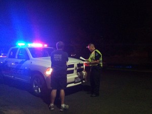  Officer Graves looks over his report as he talks to witnesses about the accident. 