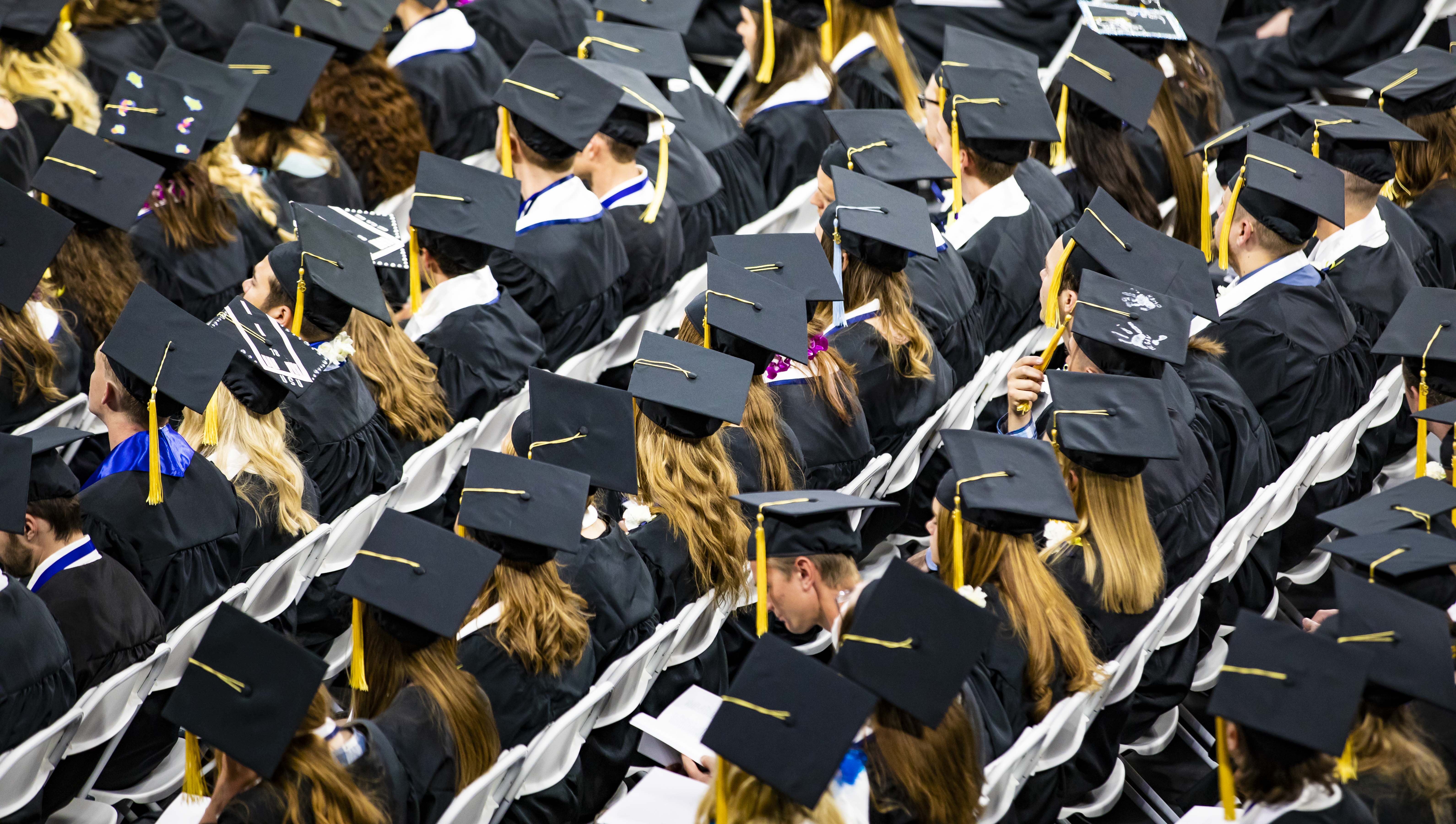 Utah State University graduates in 2018 wait to hear their names called.