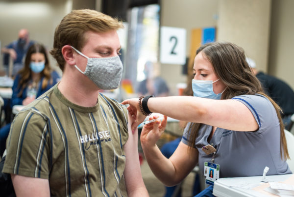 USU student Carter Ottley receives a COVID-19 vaccine at the university's on-campus clinic.