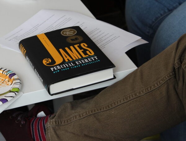 a black book sits on a small stack of papers on a white table