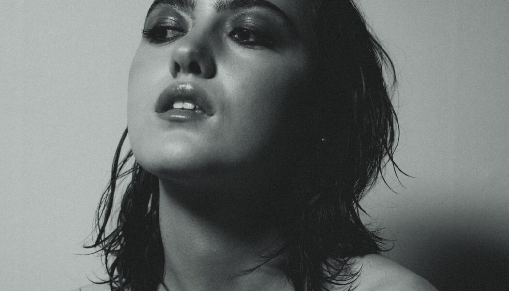 A black and white image of a woman with short dark hair, taken from the shoulders up.